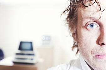 Close-up portrait of a stressed male programmer with intense blue eyes