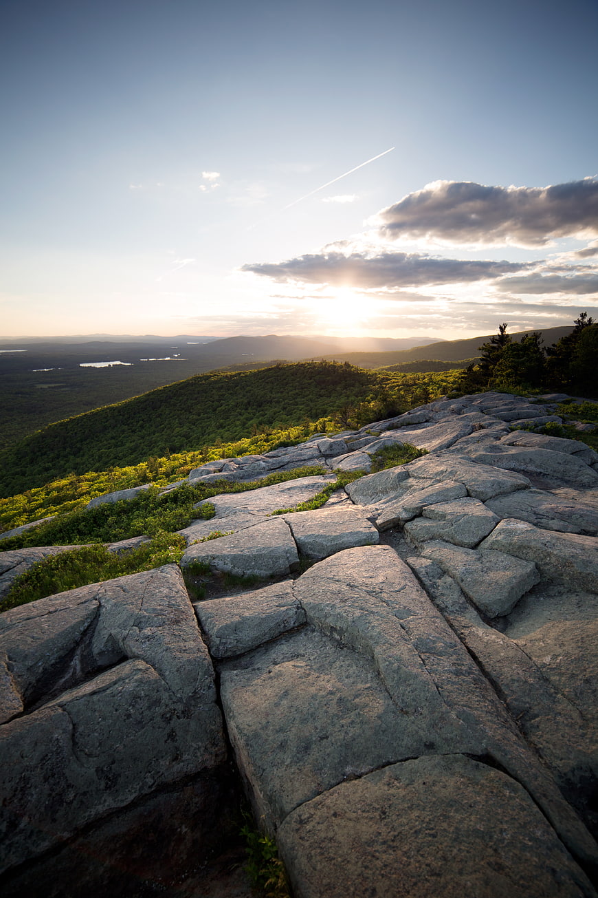 Sunset Over Rocky Mountain Summit With Forest Valley View