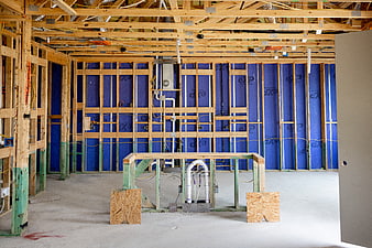 Interior House Framing with Blue Insulation and Plumbing