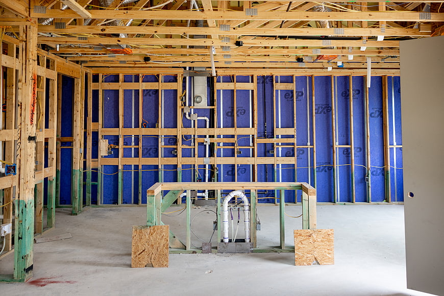 Interior House Framing with Blue Insulation and Plumbing
