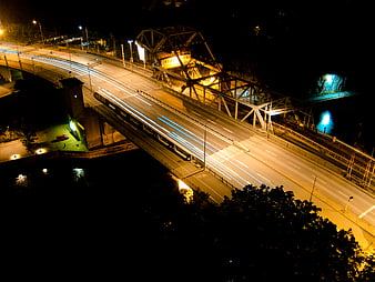 Night long exposure of illuminated bridge with light trails