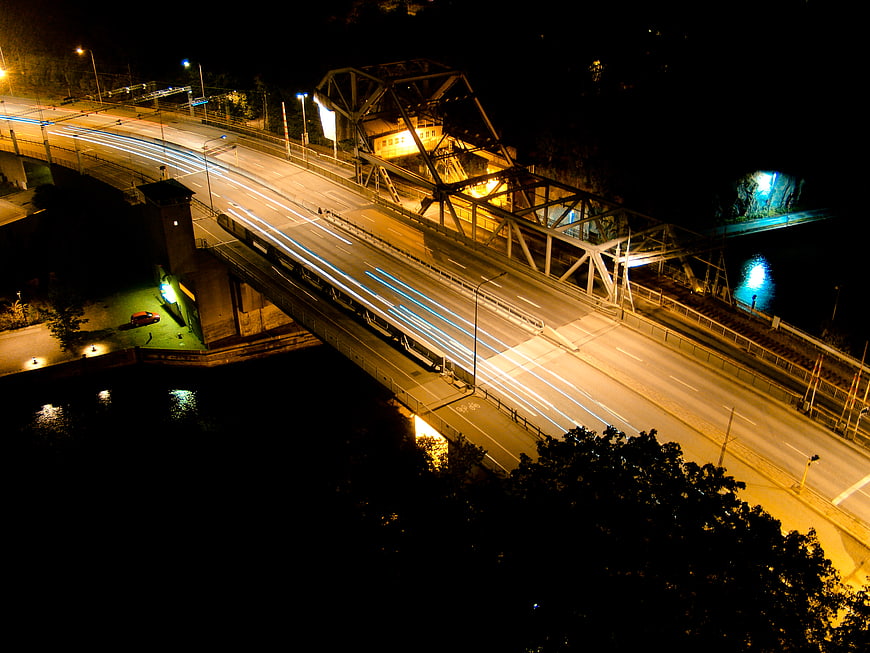 Night long exposure of illuminated bridge with light trails