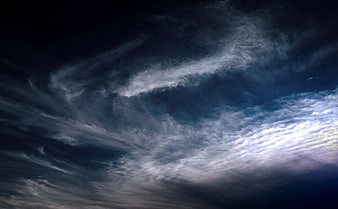 Dramatic dark blue sky with wispy cirrus clouds