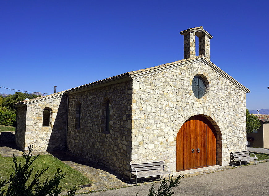 Small stone chapel with wooden door and blue sky
