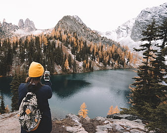 Woman in Yellow Beanie Photographing Alpine Lake