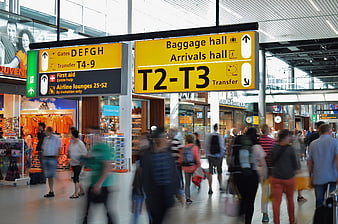 Busy Airport Terminal with Yellow Directional Signage
