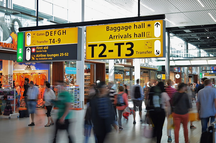 Busy Airport Terminal with Yellow Directional Signage