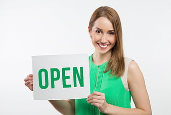 Smiling woman holding open sign on white background
