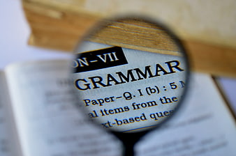Magnifying glass focusing on grammar text in a book