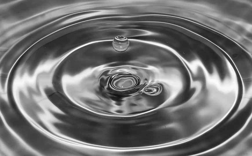 Black and white water droplet creating ripples