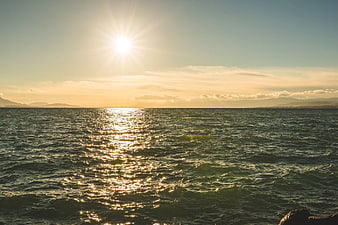 Golden Sunset Over Ocean with Distant Mountains