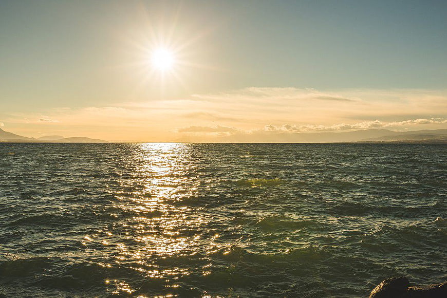 Golden Sunset Over Ocean with Distant Mountains