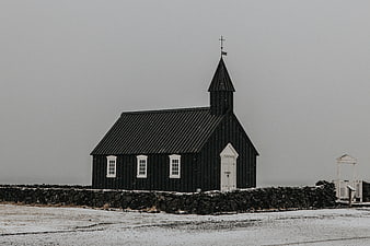 Black wooden church in snowy winter landscape