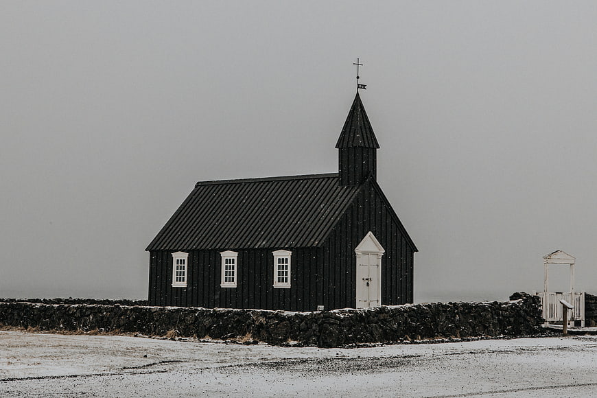 Black wooden church in snowy winter landscape