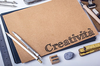 Creativity concept with sketchbook and drawing tools on white desk