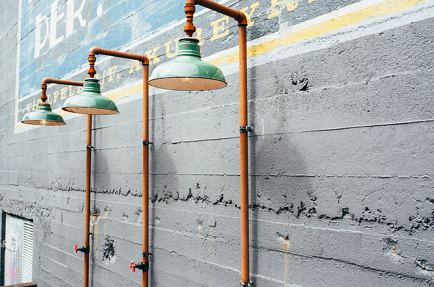 Industrial Pipe Lighting Fixtures on Textured Gray Wall