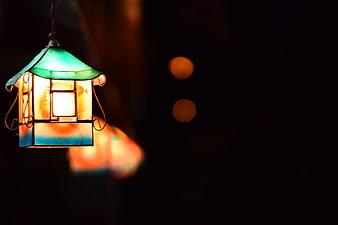 Illuminated Stained Glass Lantern Against Dark Background