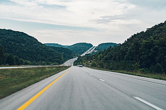 Highway Driving Through Green Mountainous Landscape