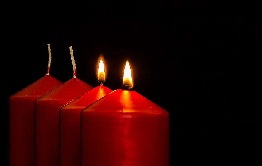 Two Lit Red Advent Candles on Black Background
