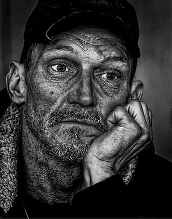 Black and white portrait of elderly homeless man with intense gaze