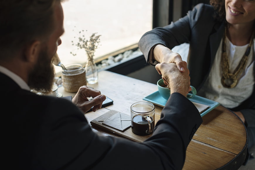 Business handshake over coffee in a cafe