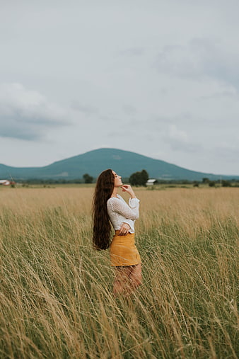 Woman in Yellow Skirt Standing in Tall Grass Field