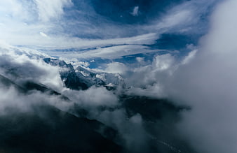 Dramatic Snowy Mountain Peaks Emerging Through Thick Clouds