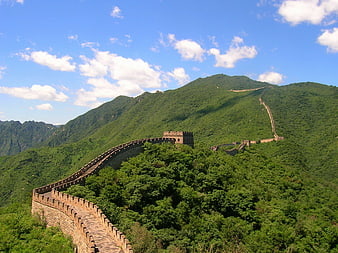 Great Wall of China winding through green mountains