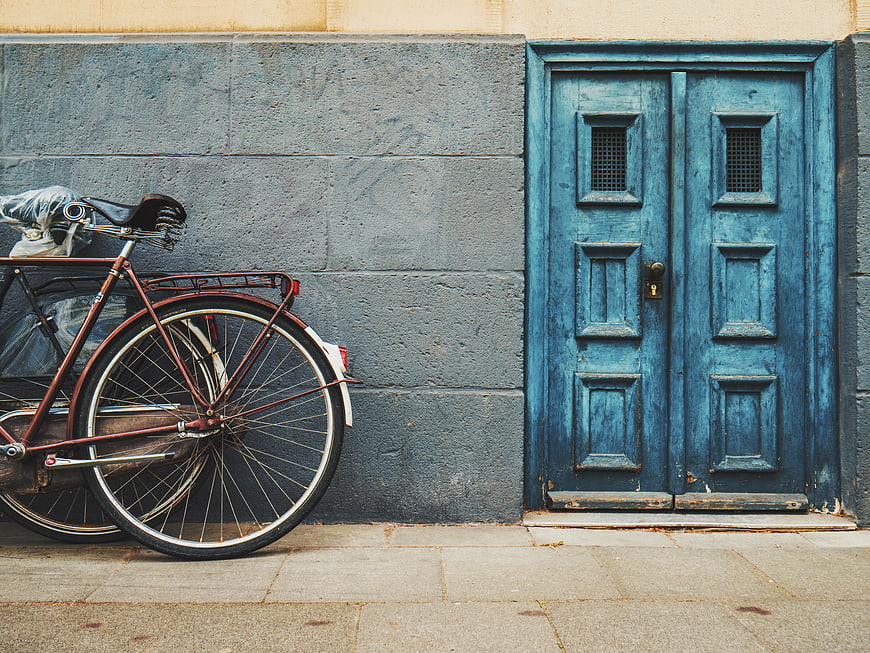 Vintage bicycle parked against a blue wooden door