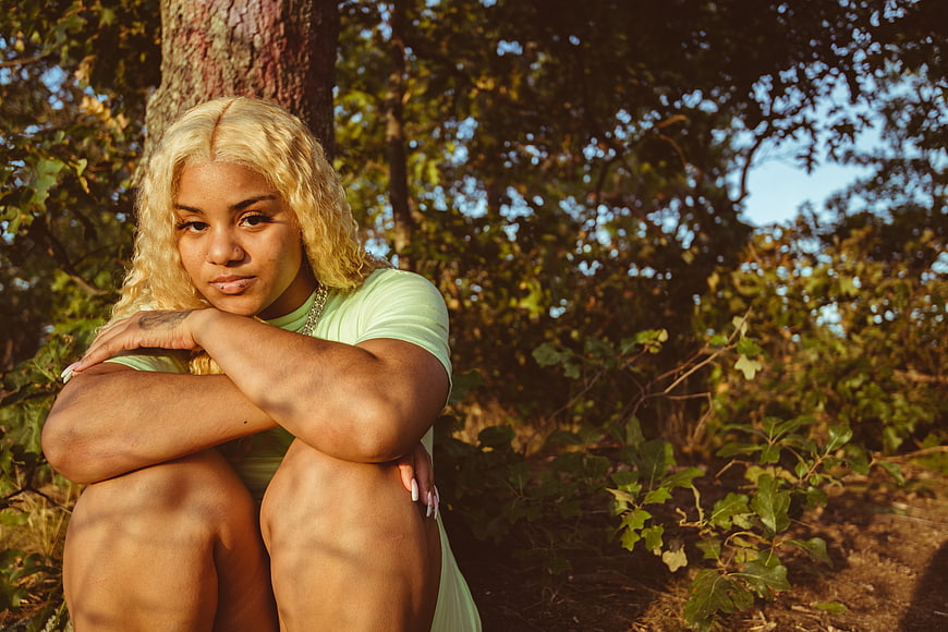Portrait of Blonde Woman Sitting in Forest