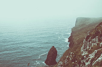Misty coastal cliffs and sea stack landscape