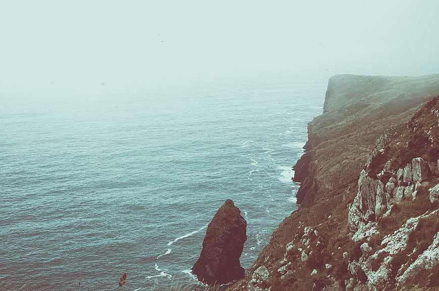 Misty coastal cliffs and sea stack landscape
