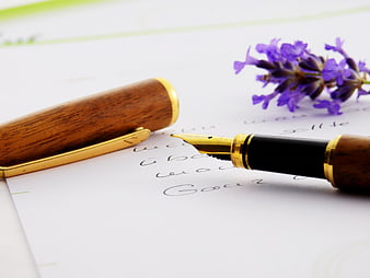 Wooden fountain pen with lavender on handwritten paper