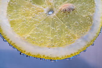 Close-up of lemon slice with bubbles in water
