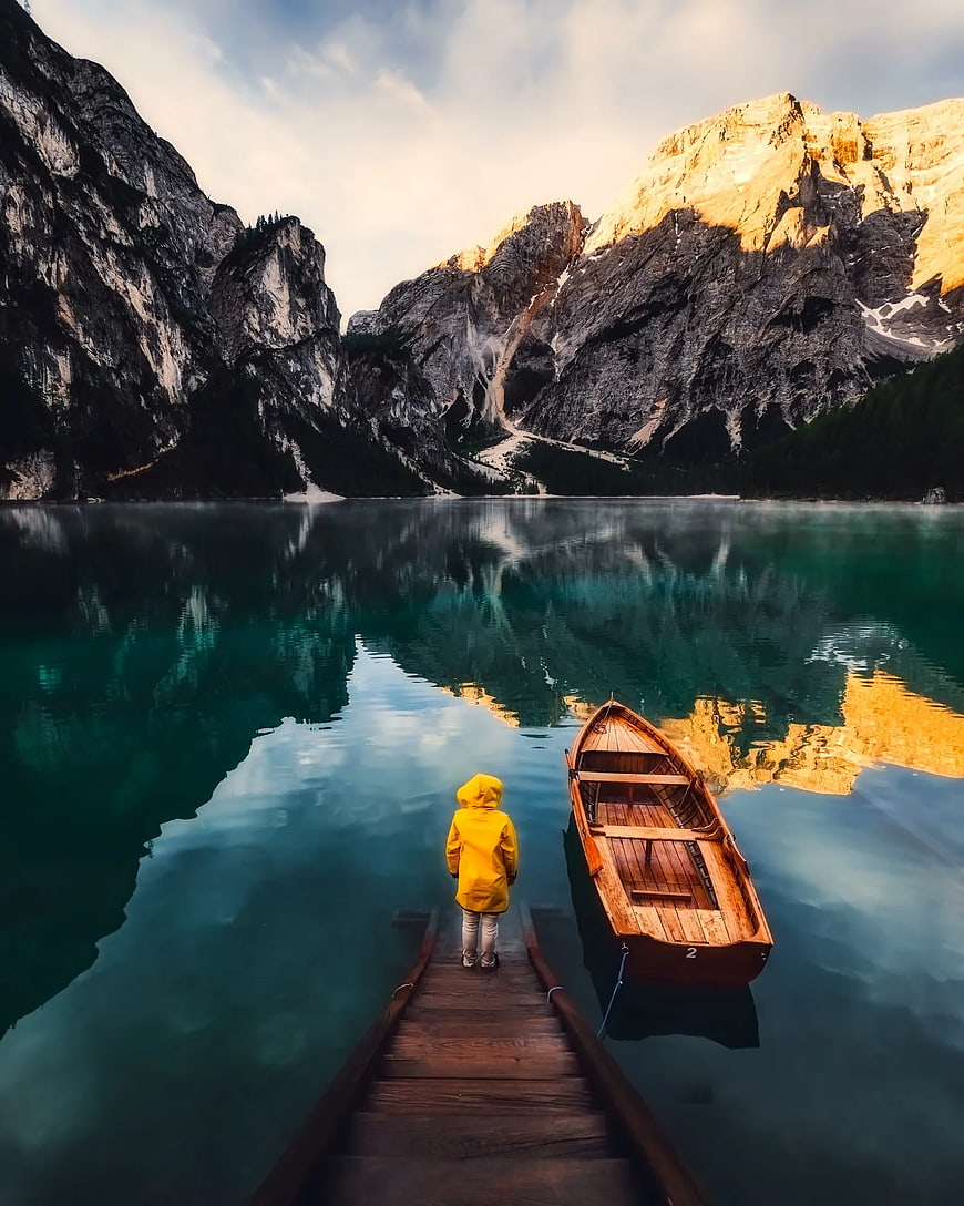 Child in Yellow Raincoat on Dock by Mountain Lake