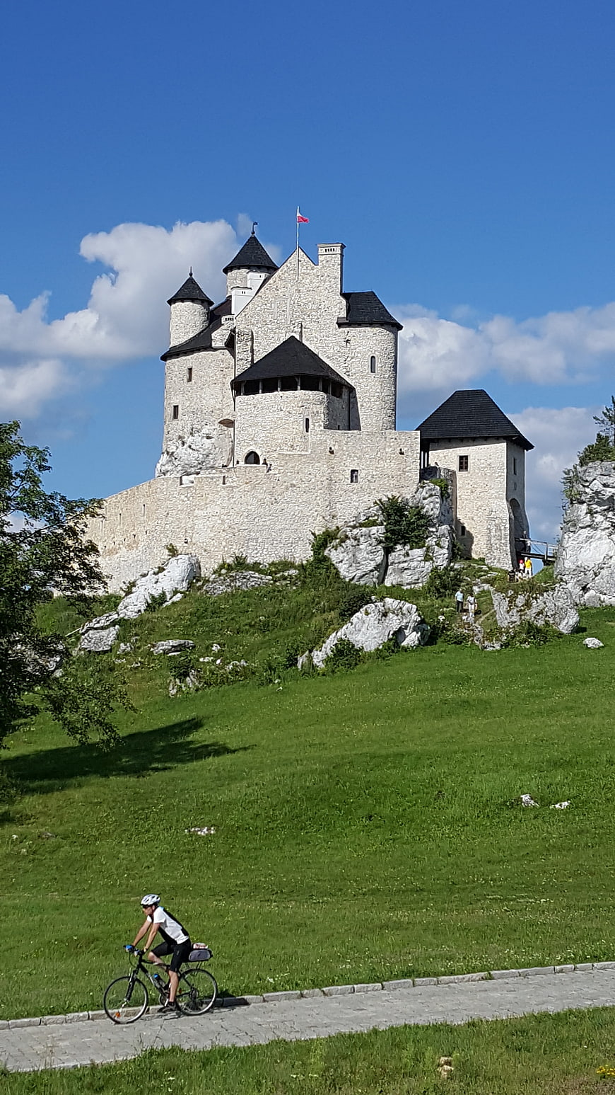 Cyclist riding past Bobolice Castle in Poland
