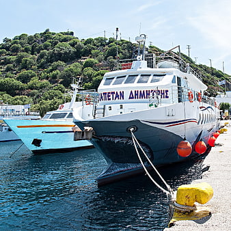 Greek passenger ferries docked in a sunny harbor
