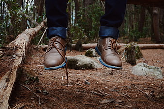 Man Wearing Brown Leather Shoes and Jeans in Forest