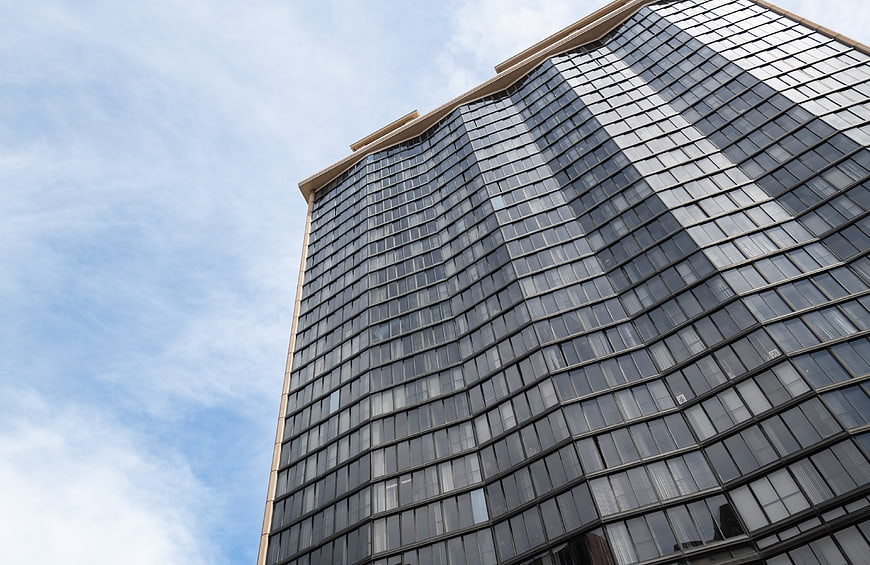 Modern Curved Glass Skyscraper Against Blue Sky