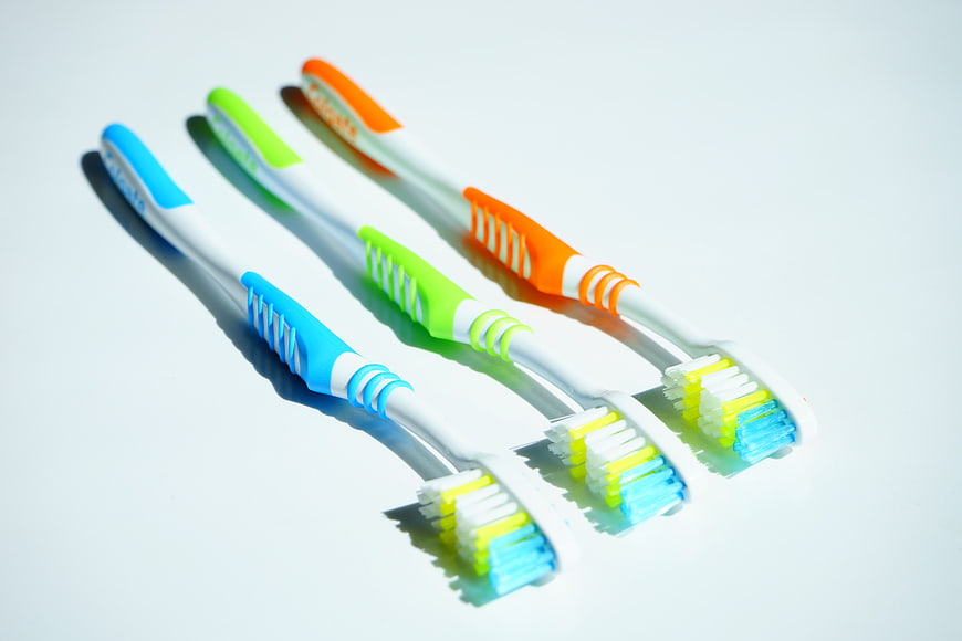 Three Colorful Toothbrushes on White Background
