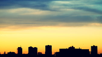 Silhouette of City Skyline Against Dramatic Sunset Sky