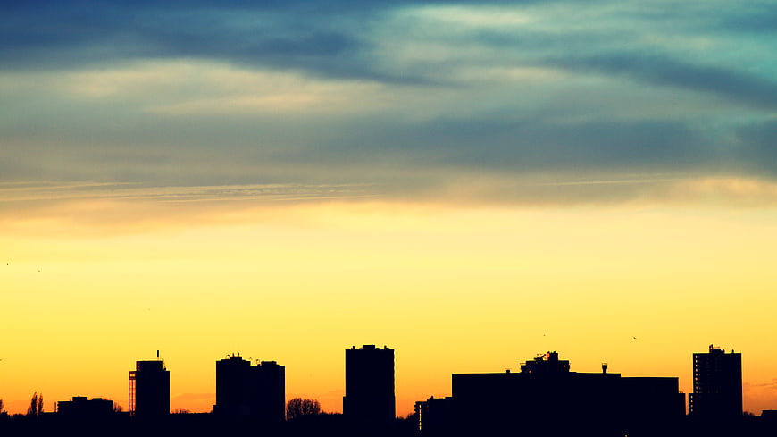 Silhouette of City Skyline Against Dramatic Sunset Sky