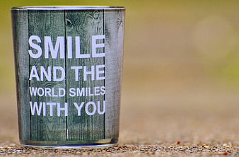 Glass with inspirational quote smile and the world smiles with you