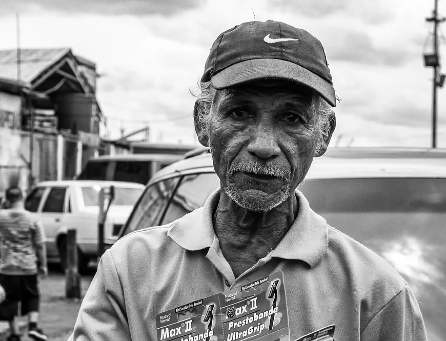 Portrait of elderly man in cap holding product packaging
