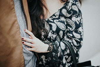 Close-up of woman's hand holding partner's jacket sleeve