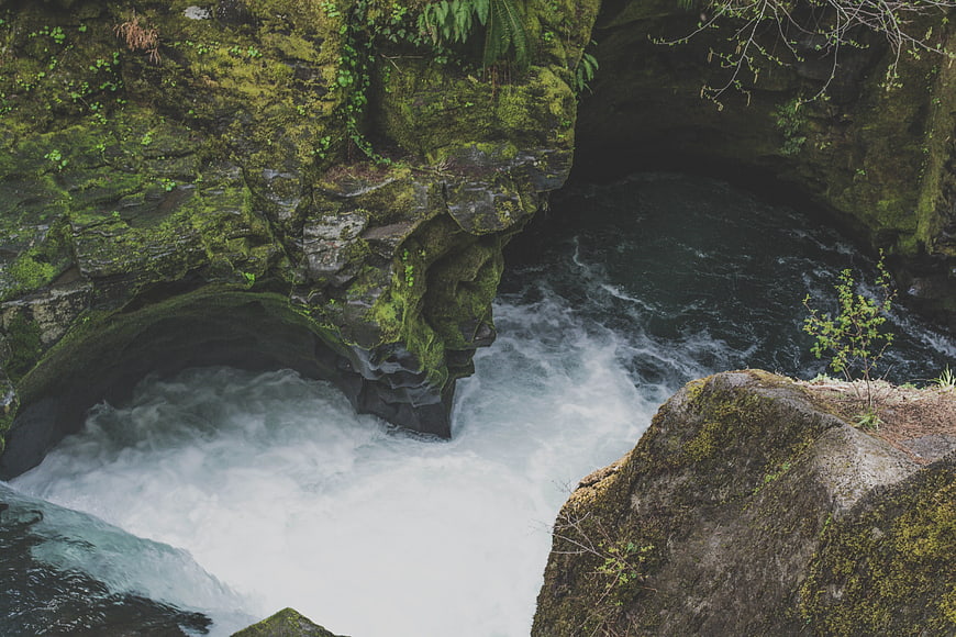 Mossy Cliff Overlooking Turbulent River Waterfall