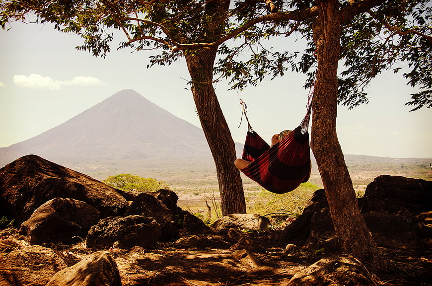 Person relaxing in hammock with volcano view