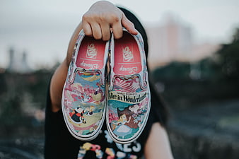Alice in Wonderland Vans Shoes Held Up Outdoors