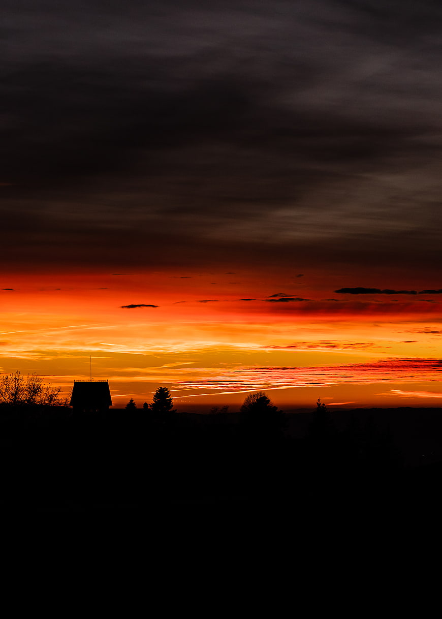 Dramatic Sunset Silhouette of House and Trees