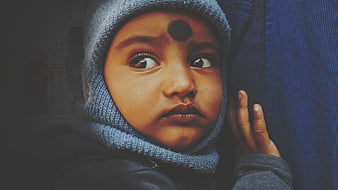 Close-up portrait of a young child in a blue knit hat